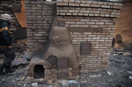 Печка. Обратите внимание, дверку топочной камеры от при пожаре растарабанило так, что купол весь в трещинах, и даже кусок отвалился.